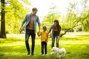 famille heureuse avec un chien bichon mignon dans le parc photo