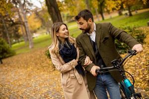 jeune couple dans le parc d'automne avec vélo électrique photo