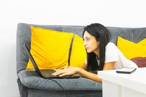 femme travaille sur ordinateur portable dans une maison confortable photo