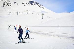 jeune adolescent caucasien apprenant à skier avec un instructeur dans les montagnes enneigées d'hiver dans la station de ski de gudauri, en géorgie. photo