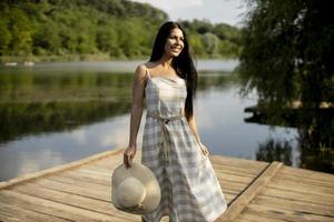 détente jeune femme debout sur une jetée en bois au bord du lac photo