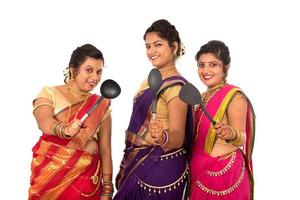 Les jeunes filles indiennes traditionnelles tenant un ustensile de cuisine sur fond blanc photo