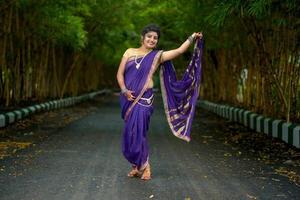 Belle jeune fille traditionnelle indienne en sari posant à l'extérieur photo
