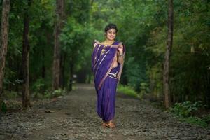 Belle jeune fille traditionnelle indienne en sari posant à l'extérieur photo