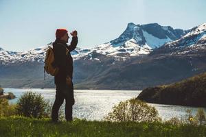 jeune homme avec un sac à dos debout sur le fond des montagnes et du lac. espace pour votre message texte ou contenu promotionnel. concept de mode de vie de voyage
