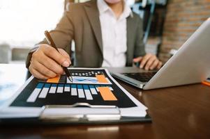 femmes comptant des pièces sur une calculatrice prenant de la tirelire. main tenant un stylo travaillant sur une calculatrice pour calculer sur le bureau le coût au bureau à domicile. photo