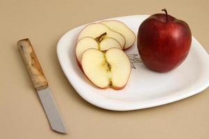 délicieuse pomme et tranche dans une assiette blanche avec couteau et fourchette