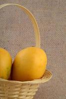 Fruits de mangue dans le panier sur fond de tissu de sac photo