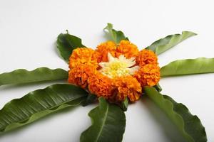 conception de rangoli de fleurs de souci avec feuille verte pour le festival traditionnel. photo