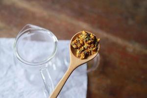 feuille de cannabis avec thé aux fleurs dans un bocal en verre pour une boisson aromatique saine