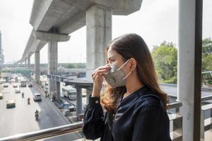 belle femme portant un masque anti-poussière protège la pollution de l'air et pm 2,5 sur la ville de la rue photo