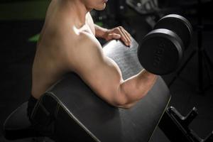 Le bodybuilder de l'homme de remise en forme musculaire est une séance d'entraînement avec des haltères dans une salle de sport photo