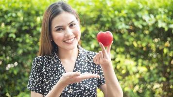 la main de la femme tient le coeur rouge, l'amour et le concept de soins de santé photo