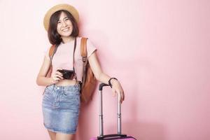heureuse femme asiatique touriste sur fond rose photo