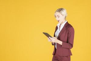 femme d'affaires est surprenante en studio fond jaune photo