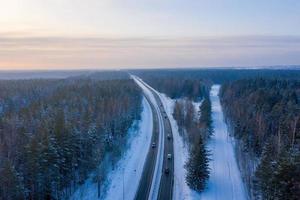 vue aérienne sur la route et la forêt en hiver. paysage d'hiver naturel de l'air. forêt sous la neige en hiver. paysage de drone photo