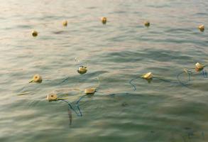 filets de pêche et cordes flottant sur la mer. photo