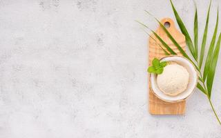 saveurs de crème glacée à la noix de coco dans la moitié de la configuration de la noix de coco sur fond de pierre blanche. concept de menu d'été et sucré.