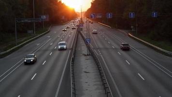 déplacer des voitures sur l'autoroute à l'heure du coucher du soleil. trafic routier au coucher du soleil avec des voitures. trafic intense sur l'autoroute, vue de dessus de la route. photo