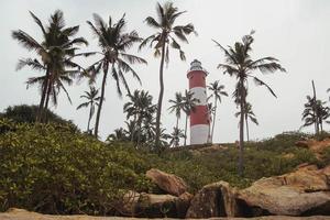 phare sur la plage au ciel dramatique du matin à kovalam, kerala, inde. copie, espace vide pour le texte photo