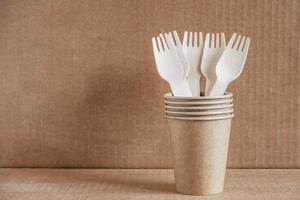 fourchettes en bois et gobelets en papier sur fond de papier kraft photo