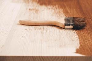 brosse avec manche en bois et poils naturels sur fond de planches de bois peintes en marron photo