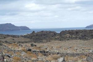 route rocheuse exotique vers le cratère du volcan. le volcan est situé dans la célèbre caldeira de Santorin. photo