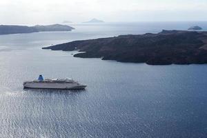 beau paysage avec vue sur la mer. bateau de croisière en mer près de nea kameni, une petite île grecque de la mer égée près de santorin. photo
