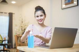 femme travaillant à domicile avec du gel hydroalcoolique photo