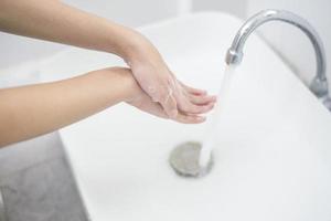 une femme se lave les mains