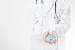 Close up doctor hand tient des pilules sur fond blanc photo