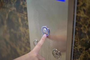 la femme appuie sur le bouton de l'ascenseur photo
