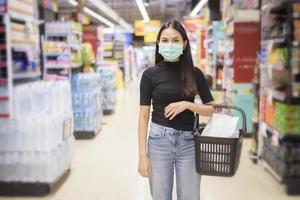 une femme avec un masque facial fait ses courses dans un centre commercial photo
