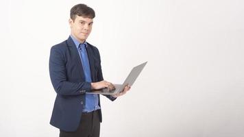 Portrait de jeune homme d'affaires utilise un ordinateur portable sur fond blanc studio photo