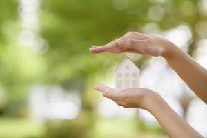 gros plan femme main tient maison sur fond vert photo