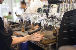 barista faisant une tasse de café par machine à café in cafe photo