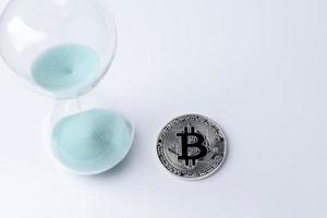 bitcoin d'argent et sablier sur fond blanc. photo