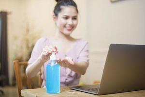 femme travaillant à domicile avec du gel hydroalcoolique photo