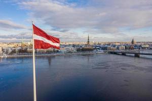 vue panoramique sur la ville de riga avec un grand drapeau letton au bord de la rivière daugava. esprit letton. photo