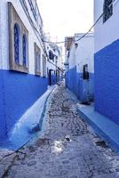 ruelle étroite avec des maisons marocaines traditionnelles peintes en bleu et blanc