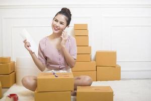 une femme prépare des produits avec des boîtes en carton pour l'expédition. photo