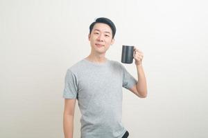 jeune homme asiatique tenant une tasse de café photo