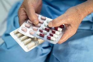 Asiatique senior ou vieille dame vieille femme patiente tenant des pilules capsules d'antibiotiques