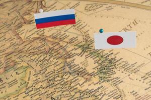 les drapeaux de la Russie et du Japon sur la carte du monde. photographie conceptuelle, différences politiques dues à l'île de sakhaline photo