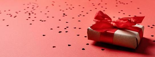 coffret cadeau rouge avec un ruban pour la saint valentin célébrant sur fond solide rouge avec espace de copie