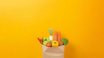 légumes dans un sac d'épicerie sur fond jaune photo