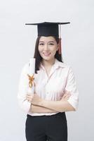 un portrait d'une belle jeune femme asiatique avec une casquette d'éducation sur fond blanc studio, concept d'éducation. photo