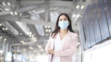 une femme d'affaires porte un masque de protection à l'aéroport international, voyage sous la pandémie de covid-19, voyages de sécurité, protocole de distanciation sociale, nouveau concept de voyage normal