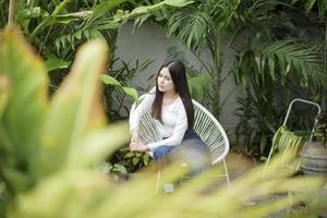 une jeune femme en vêtements blancs portrait avec des plantes vertes photo