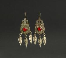 boucles d'oreilles antiques anciennes avec des pierres sur fond noir. bijoux vintage d'asie moyenne photo